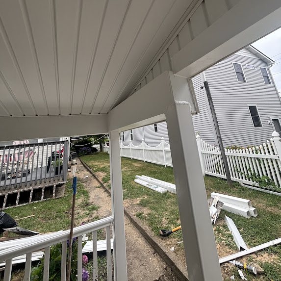 Porch post and beam wrapped in white PVC trim coil