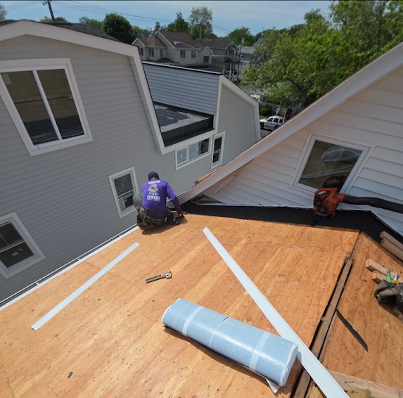 Gutter Bandits crew member on a stripped roof deck during a tear-off in Bradley Beach NJ