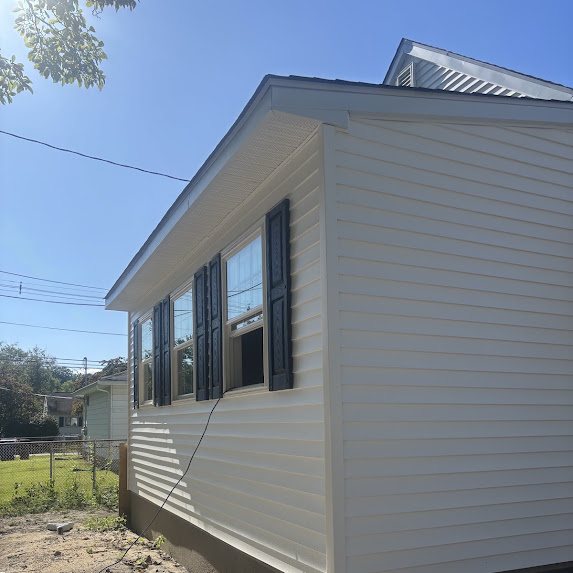 New white soffit and gutter line above windows with black shutters