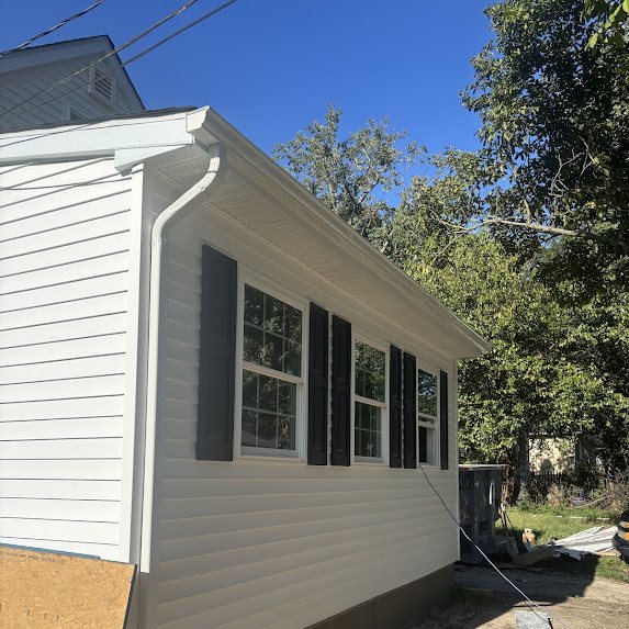New construction home in Browns Mills NJ with white siding, black shutters, and new white 5-inch K-style gutters