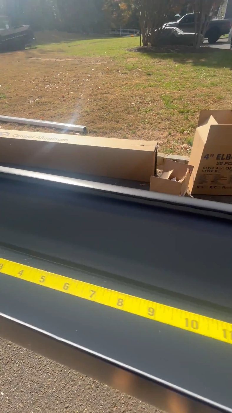 Black 6-inch K-style seamless gutter being measured with a tape on site in Colts Neck