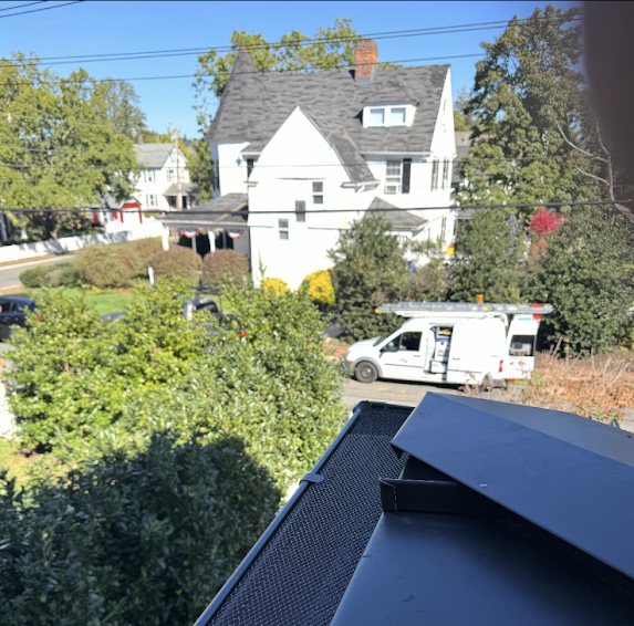 Installed gutter guard with the Gutter Bandits work van parked on the street below