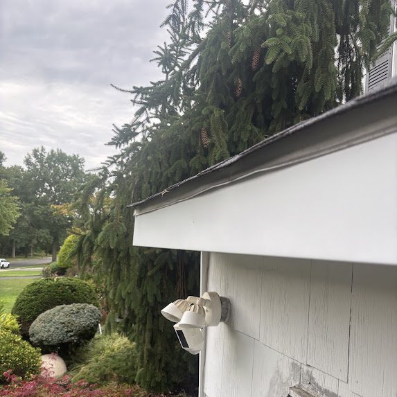 Roof edge with the old gutter removed showing the bare fascia line on a white house in Freehold NJ