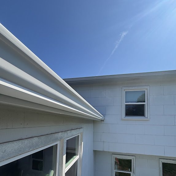 View along a new white seamless gutter from the roof of a Freehold Township home