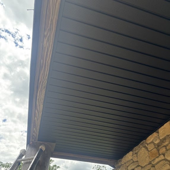 Angled view of completed black soffit panels along timber beam