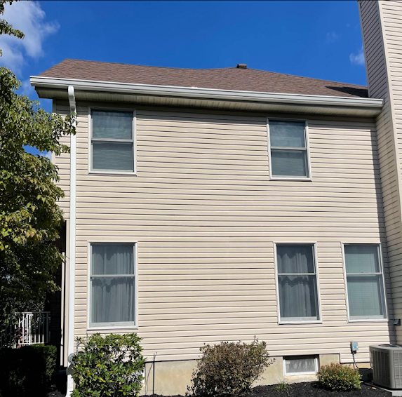 Side elevation of a two-story Marlboro home with new white gutters