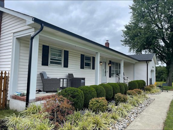 White ranch home in Millstone Township NJ with new black 5-inch seamless gutters and black shutters