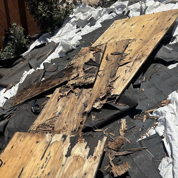 Rotted plywood roof decking uncovered during a tear-off in Millstone Township