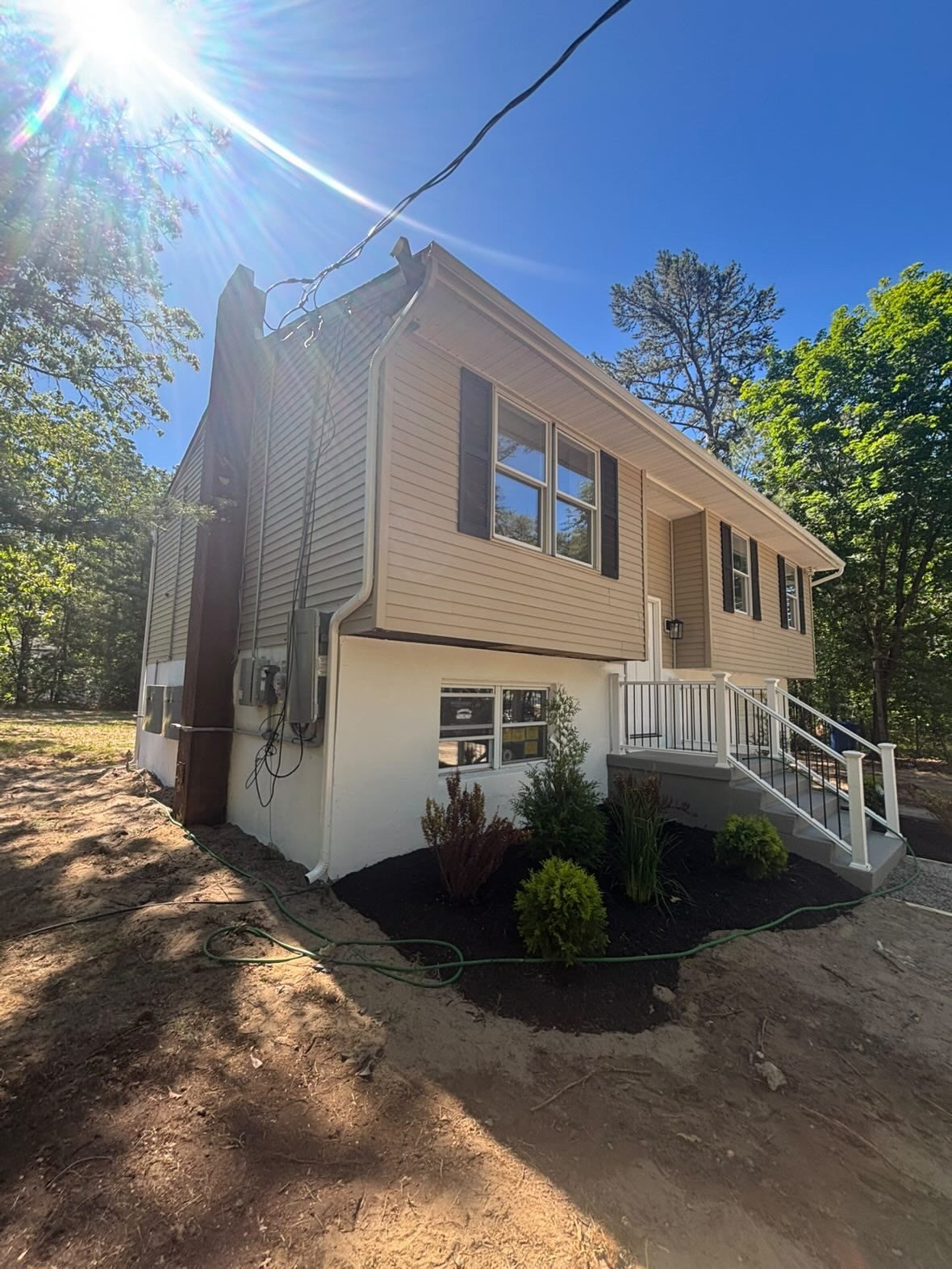 Installer setting a white gutter on a renovated ranch