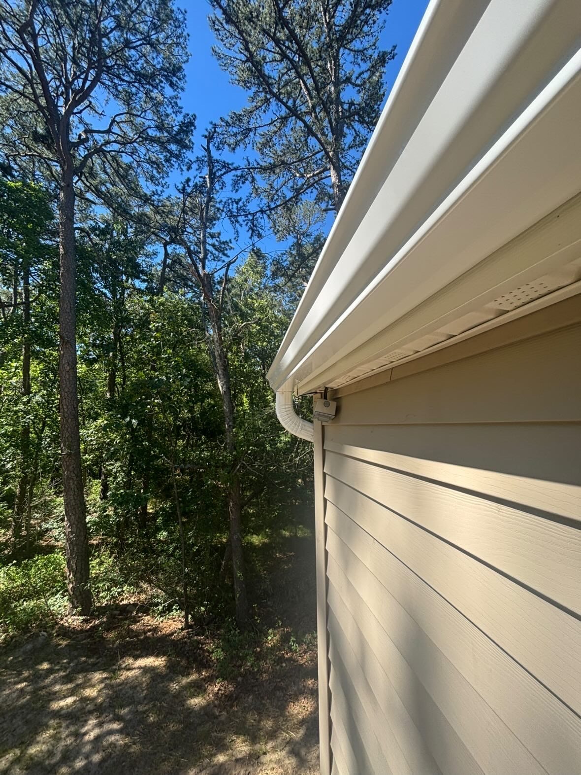 Rear corner of a renovated ranch with new white gutters
