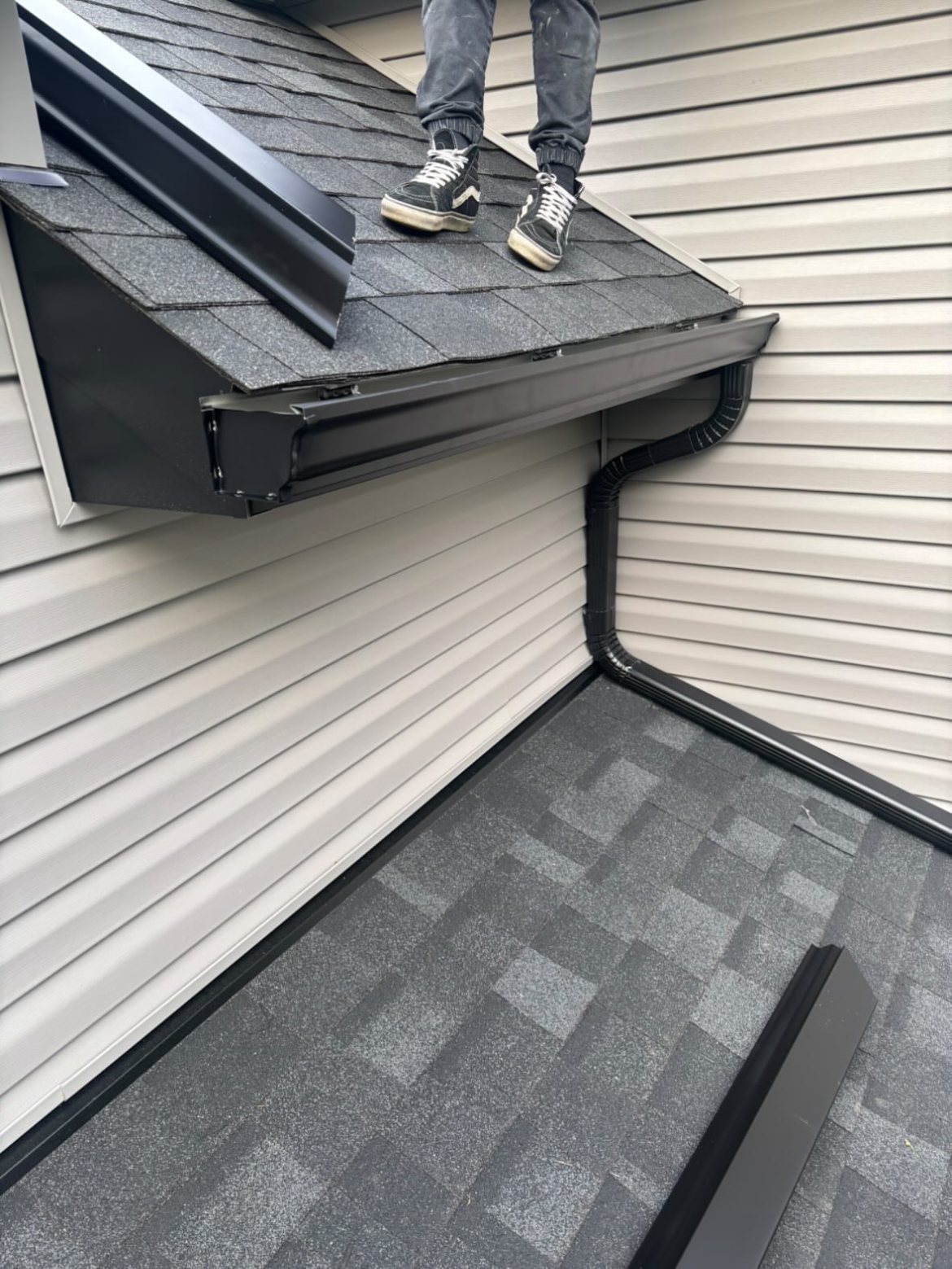 Black gutter inside corner with downspout in Millstone Township