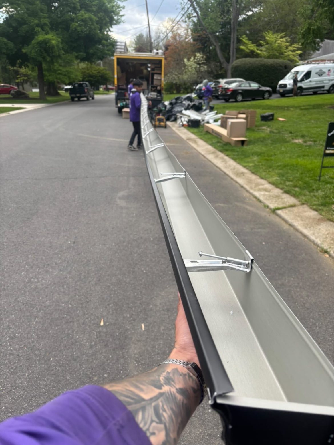 Black seamless gutter formed on-site at the curb in Millstone Township