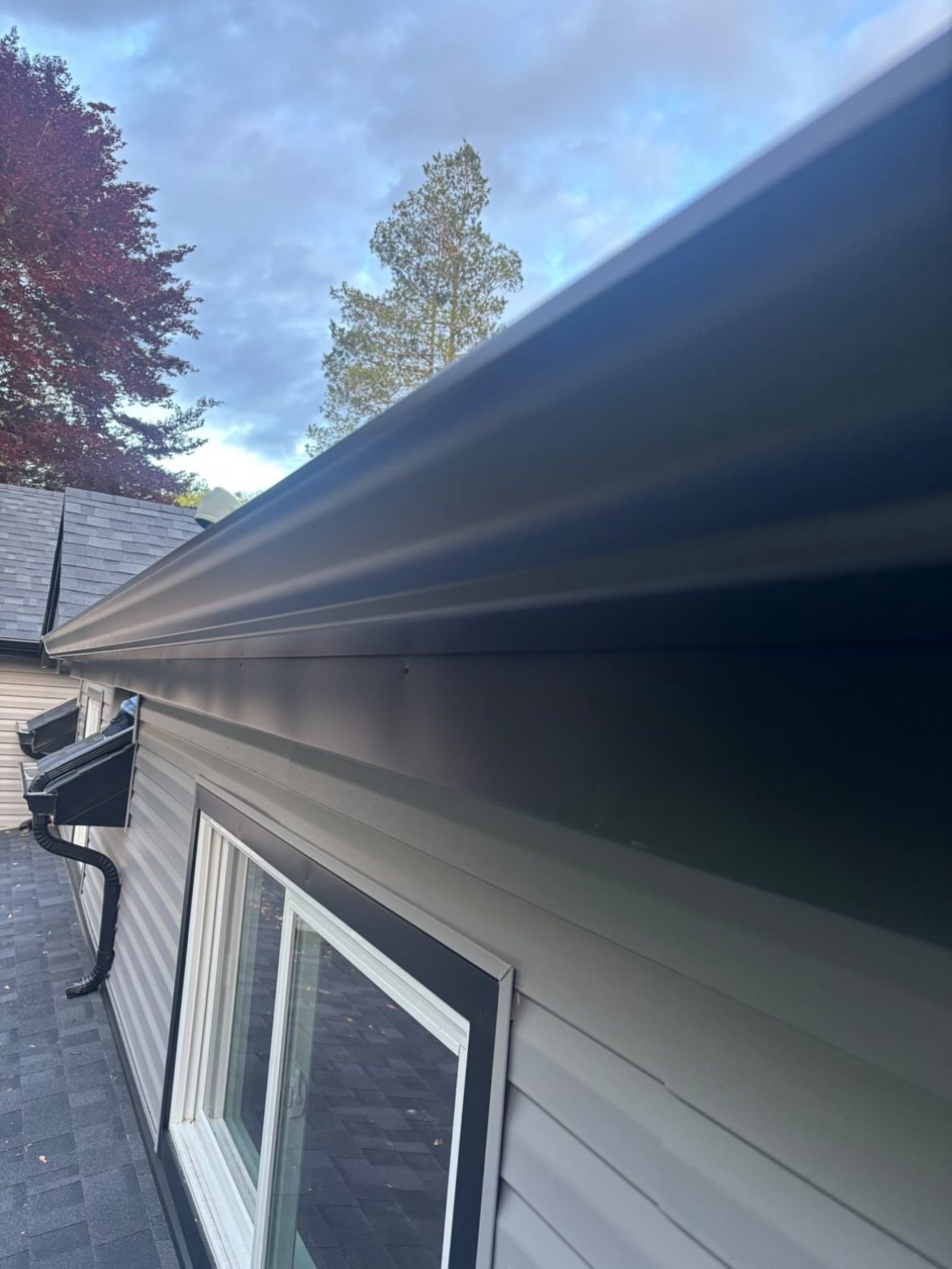Black seamless gutter line above windows on a Millstone Township home