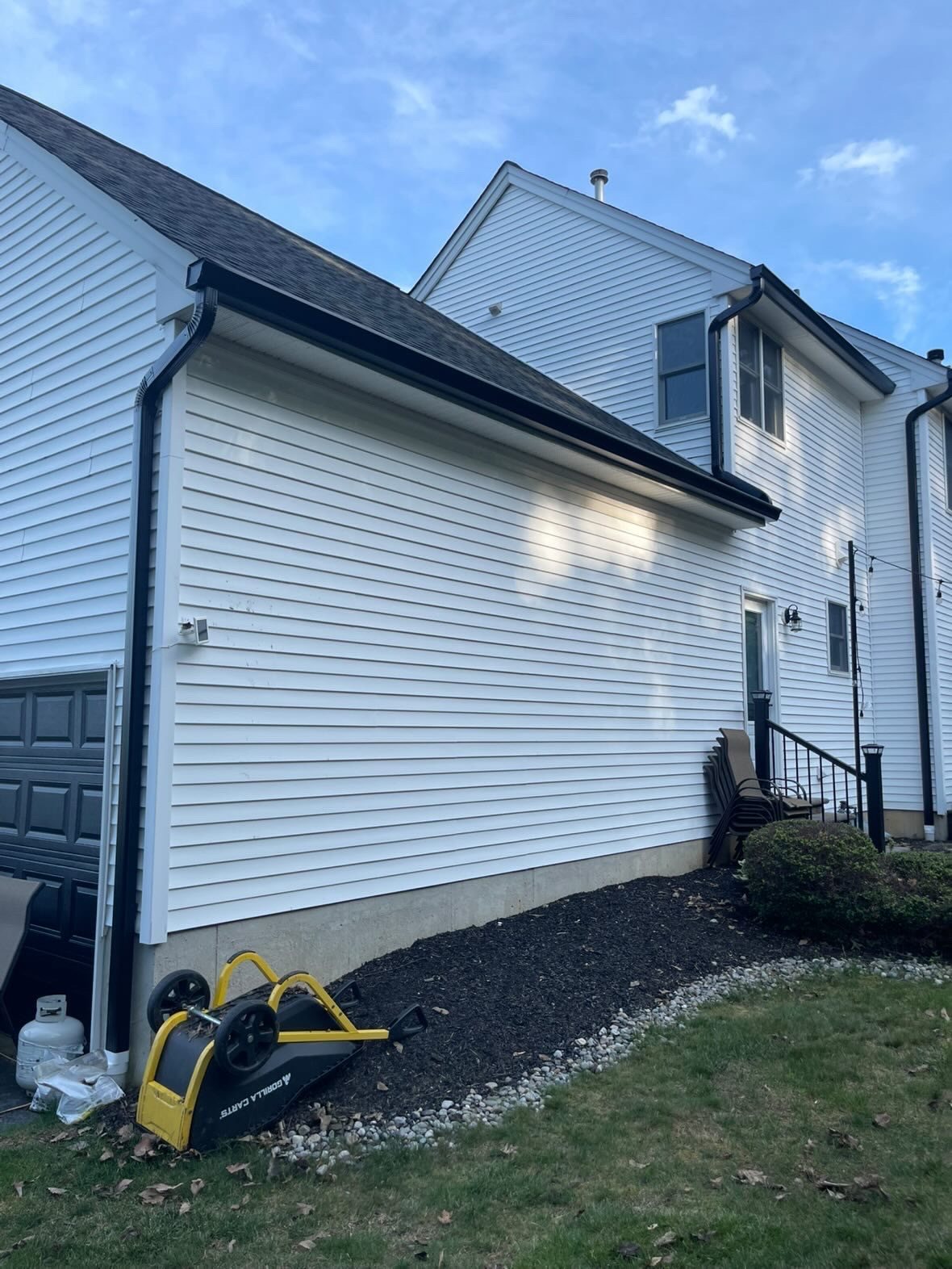 Black downspout on the garage side of a Millstone Township home