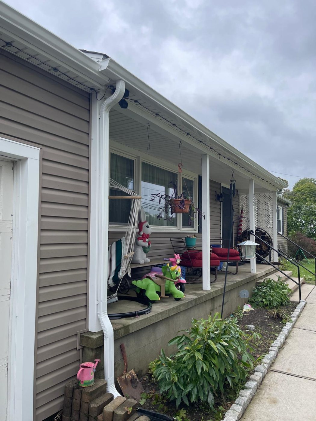 White seamless gutter running across the front porch roofline of a Millstone NJ ranch