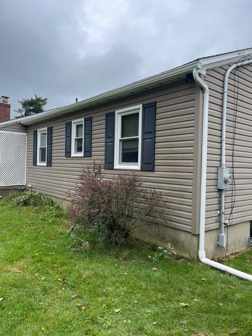 New white 5-inch K-style gutter and 2x3 downspout on a tan-sided ranch home in Millstone Township NJ
