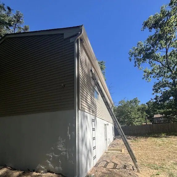 Rear downspout routed to carry water clear of the foundation
