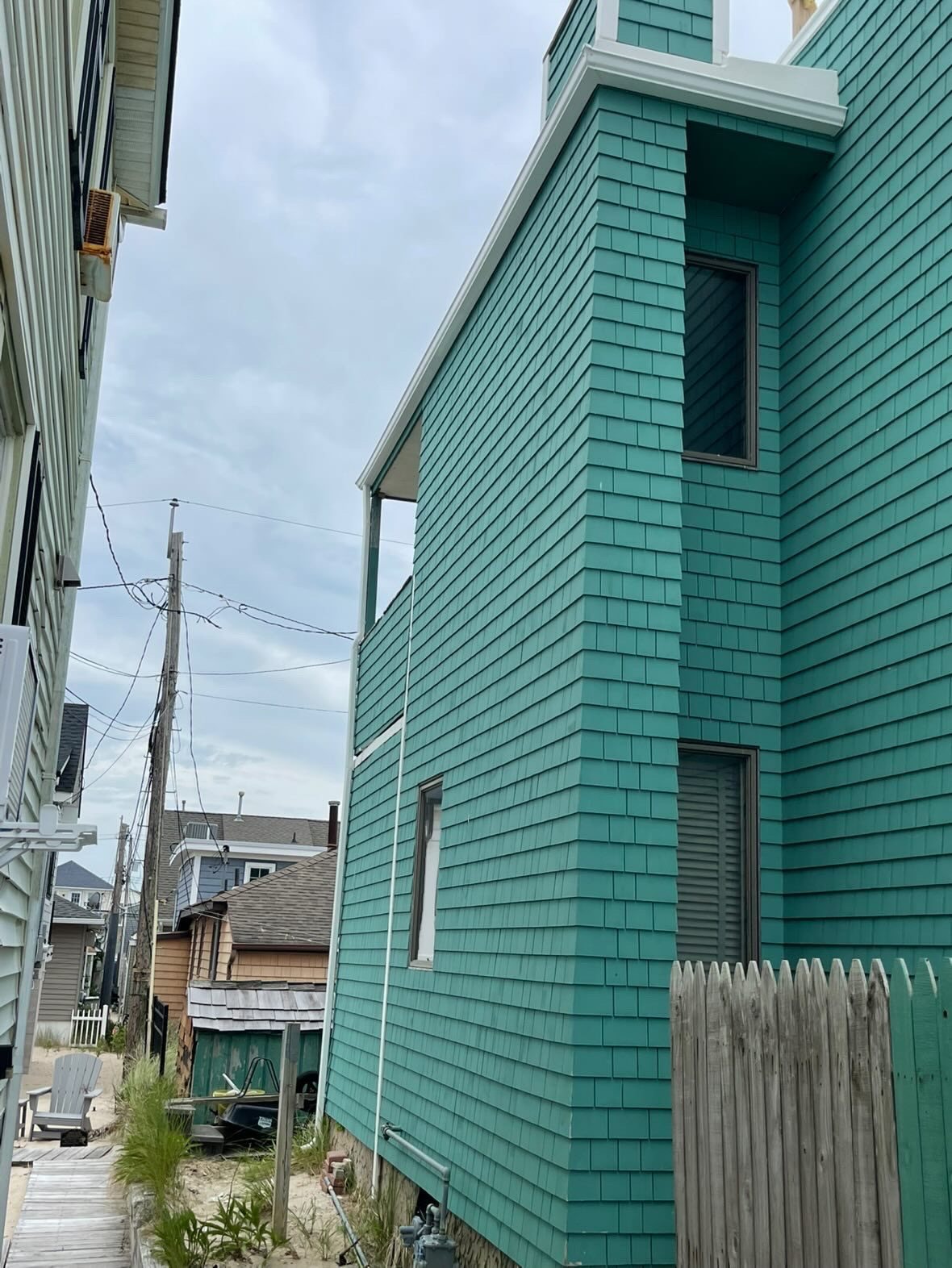 Side elevation of a teal waterfront home with white gutters