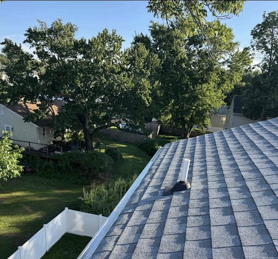 Roofline with new gutter guards under mature trees in Port Monmouth