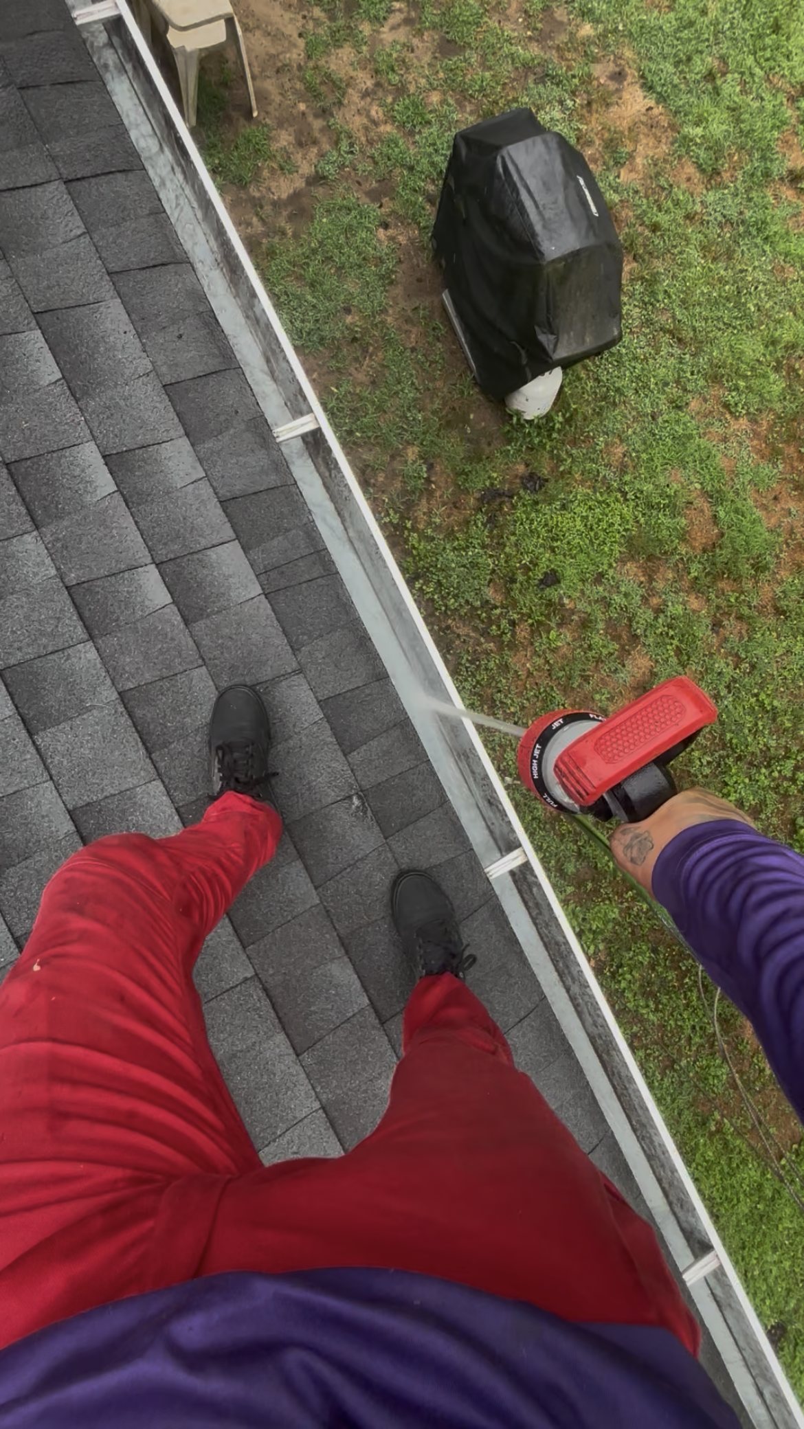 Crew member hose-flushing a gutter during a cleaning in Roosevelt