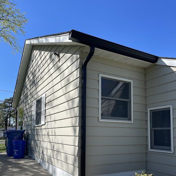 Beige siding home — black gutters complete the modern look