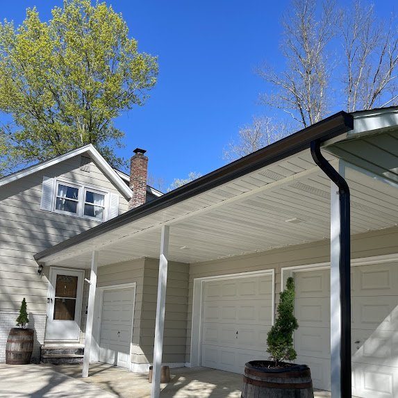 Front view — black gutters define the roofline against beige siding