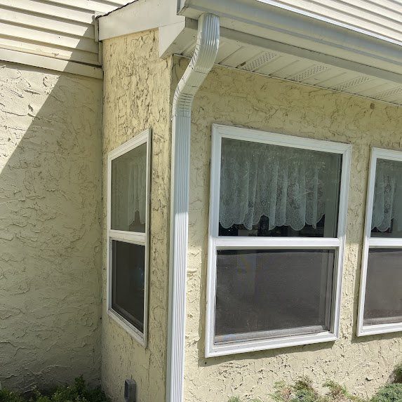 Detail of new gutter and downspout transition on stucco